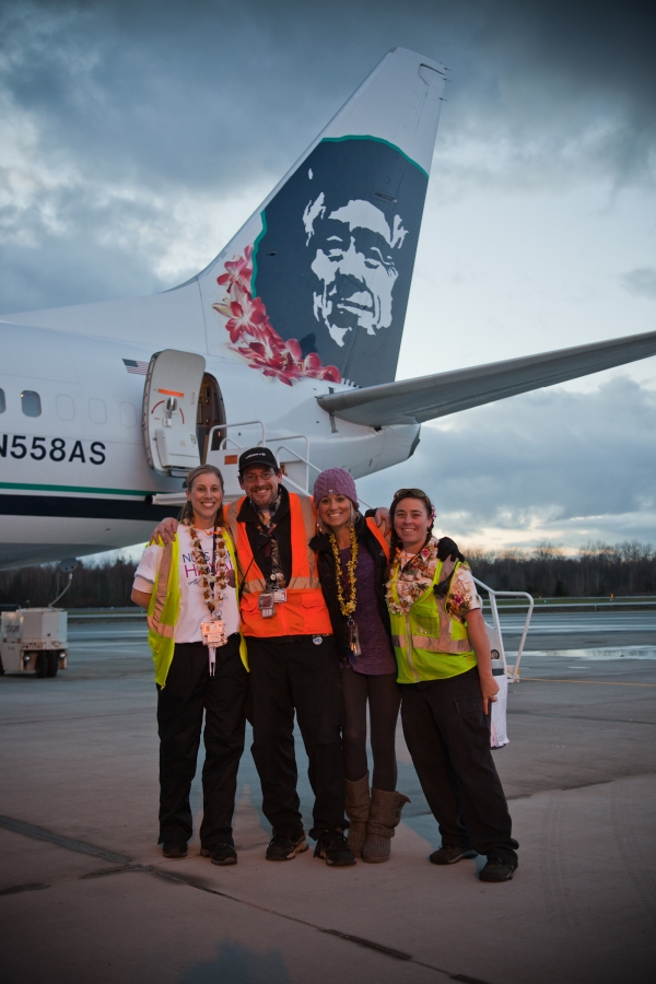 Alaska crew poses in front of their plane.