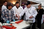 Executive chef Pat Donahue directs Nestor Guillermo on how to cut the 55 pound behemoth salmon for each chef. (Photo by Jeremy Dwyer-Lindgren/NYCAviation)