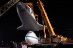 With Enterprise held by two cranes, the Shuttle Carrier Aircraft is pushed back. (Photo by Guy Dickinson, CC BY-SA)
