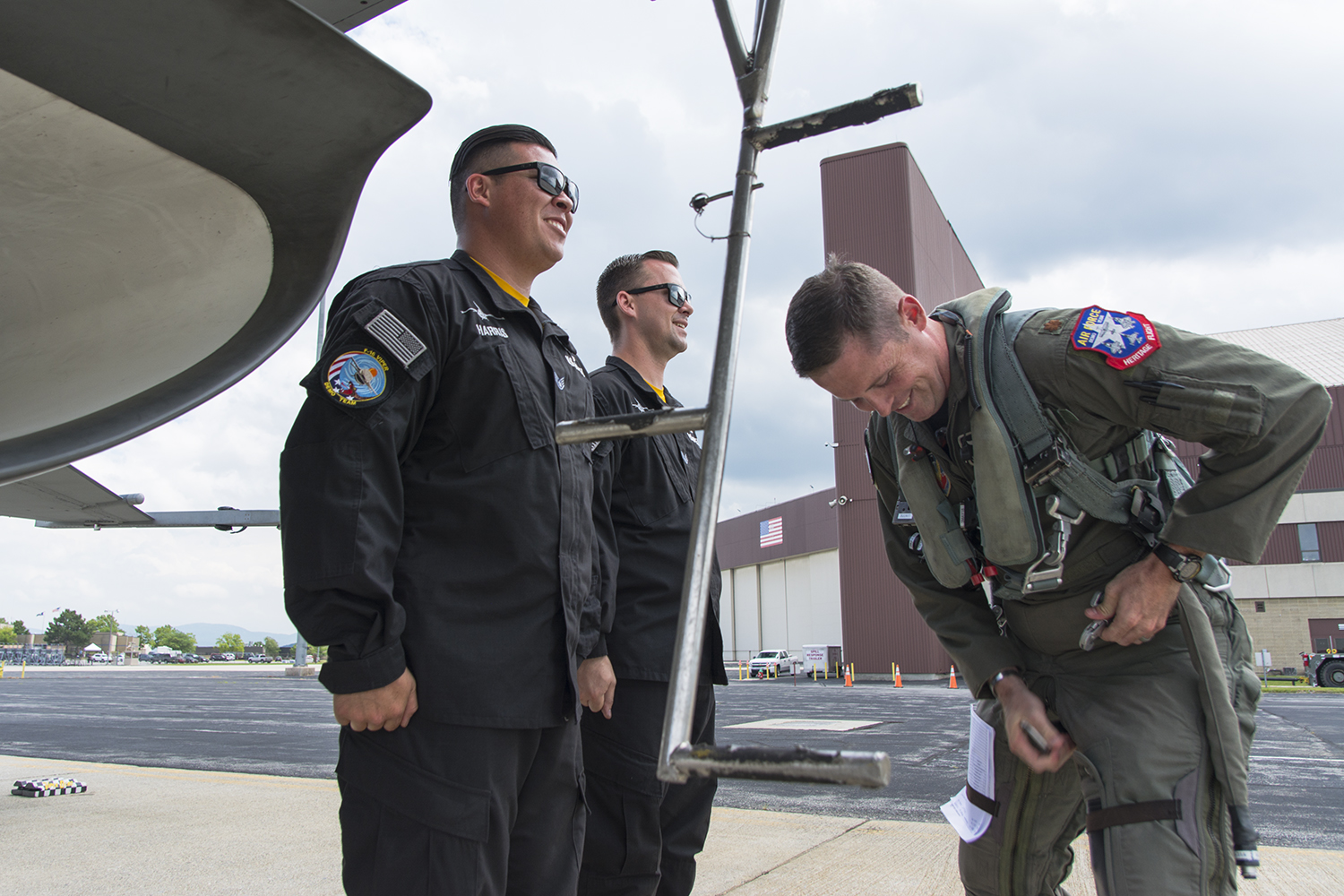 All smiles from SSgt. Billy Harris, left, and SSgt. Dominic Dizes, right, as Maj. John “Rain” Waters suits up.