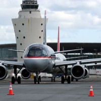 US Airways (N767UW) and Northwest (N371NB) Airbuses taxi to the active at LaGuardia with the classic control tower and Central Termi