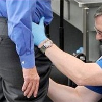 TSA agent pats down an airport passenger.
