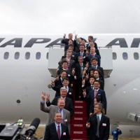 Officials from Japan Airlines, Boeing and GE pose for a photo with the carrier's newly delivered 787 Dreamliner.