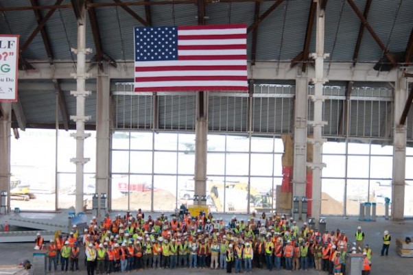 LAWA staff, construction workers from Walsh-Austin Joint Venture, and special guest, veteran Pete Howenstein pose in the great hall of the South Concourse with an American flag during a pre-Memorial Day tribute, May 24, 2012. (Photo by Stephen Shrank/NYCAviation)