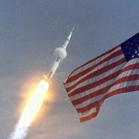 Apollo 11 flies towards earth orbit with the American flag in the foreground. (Photo by NASA)