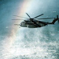 A rainbow is formed in the mist rising from the ocean as a Helicopter Mine Countermeasures Squadron 15 (HM-15) MH-53E Sea Dragon helicopter conducts mine countermeasures operations near Naval Air Station, Alameda, Calif. (Photo by John Gaffney/US Navy)
