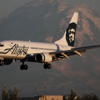 A clear day in Seattle allows distant Mt. Rainier to make an appearance behind an Alaska Airlines Boeing 737-700 (N626AS) approaching SeaTac. (Photo by Brandon Farris)