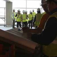 Construction workers examine blueprints inside the new Sky Club.