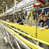 737 wing mechanics Jon Powell, Jared Sanchez, Ron Doleman, Mike Graham and Ron McNabb lift a 737 wing spar part into the automated spar assembly tool. (Photo courtesy of Boeing)