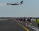 A Delta Boeing 737 on short final for runway 31R as JFK Runway Run participants run down runway 4R.