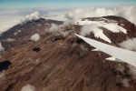 Mount Kilimanjaro is seen  peeking through the clouds out the window of the 787 Dreamliner. (Photo by Jeremy Dwyer-Lindgren)