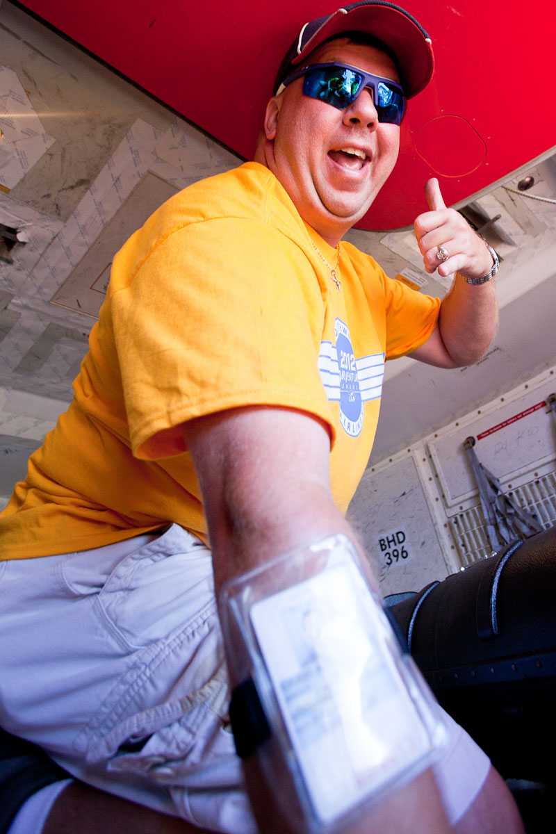 An employee climbs into the cargo hold and begins unloading boxes at OSH.
