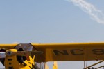 A civilian Cub rests while warbirds perform above.