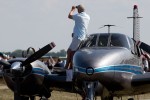 An owner stands on the wing of his twin-prop to watch the show.