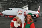 Santa Claus and one of his elves pose in front of the Air Berlin Santa Claus Tour 2012 Boeing 737 (D-ABMJ). (Photo by Air Berlin)