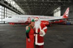 Santa Claus and one of his elves pose in front of the Air Berlin Santa Claus Tour 2012 Boeing 737 (D-ABMJ). (Photo by Air Berlin)