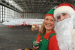 Santa Claus and one of his elves pose in front of the Air Berlin Santa Claus Tour 2012 Boeing 737 (D-ABMJ). (Photo by Air Berlin)