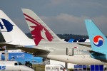 Tail fins of a Korean Air Boeing 737-900ER, a Qatar Airways Boeing 787-8 Dreamliner, and a Malaysia Airlines Airbus A380. (Photo by Farnborough International)