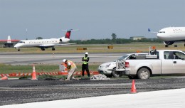 Construction personnel are seen completing work on the north side of the Bay Runway as two arriving aircraft taxi to the terminal