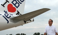 JetBlue CEO David Barger poses with the I Heart JetBlue Airbus A320 at Oshkosh 2011.