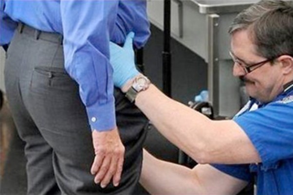 TSA agent pats down an airport passenger.