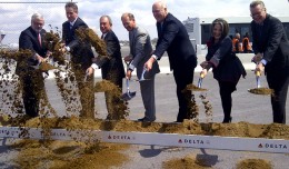 Delta executives, New York Mayor Mike Bloomberg and other local politicians take part in the ceremonial first dig for the 630-foot long bridge that will connect Terminals C and D.
