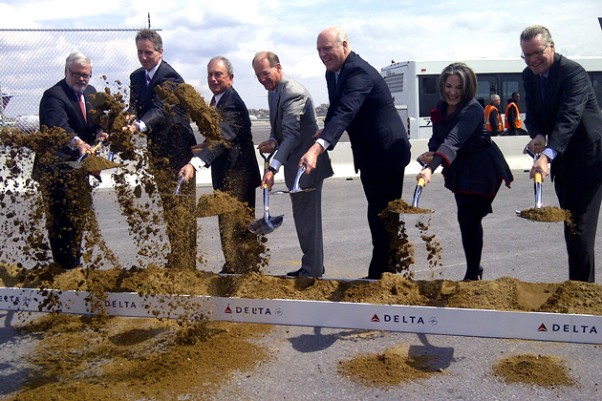 Delta executives, New York Mayor Mike Bloomberg and other local politicians take part in the ceremonial first dig for the 630-foot long bridge that will connect Terminals C and D.