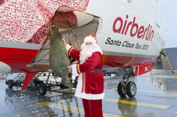 Santa loads a tree onto Air Berlin's "Santa Claus Tour 2012" Boeing 737. (Photo by Air Berlin)