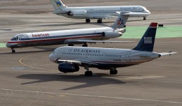 An American Airlines MD-80 and a US Airways A319 meetup while an Allegiant MD-80 rolls by in Vegas. (Photo by g Tarded via Flickr, CC-BY-ND)