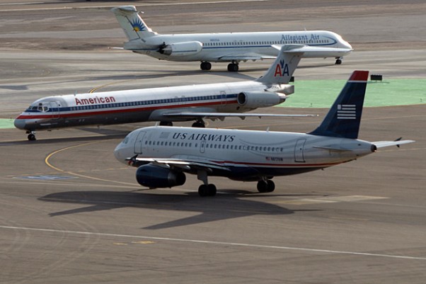 An American Airlines MD-80 and a US Airways A319 meetup while an Allegiant MD-80 rolls by in Vegas. (Photo by g Tarded via Flickr, CC-BY-ND)