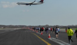 A Delta Boeing 737 on short final for runway 31R as JFK Runway Run participants run down runway 4R.