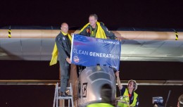 The Solar Impulse crew holds up a banner after completing their cross crountry journey